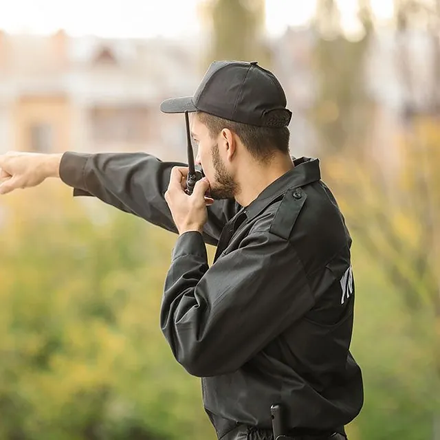 Wachmann am Funkgerät zeigt auf etwas - WSL – Wach & Sicherheitsdienst Lippe uG